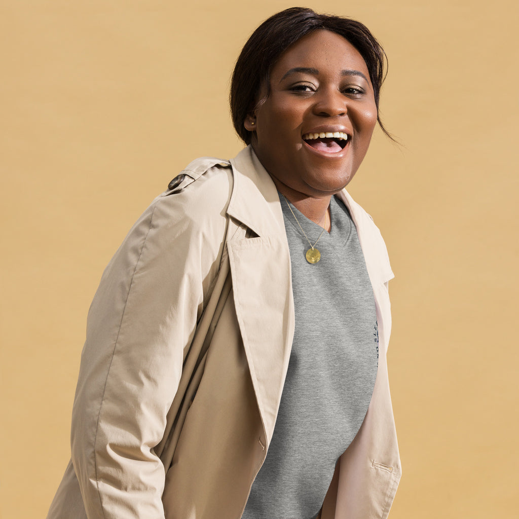 Image of a Black woman wearing a grey sweatshirt  with the design "no sleep reader society" and a cream trench coat.