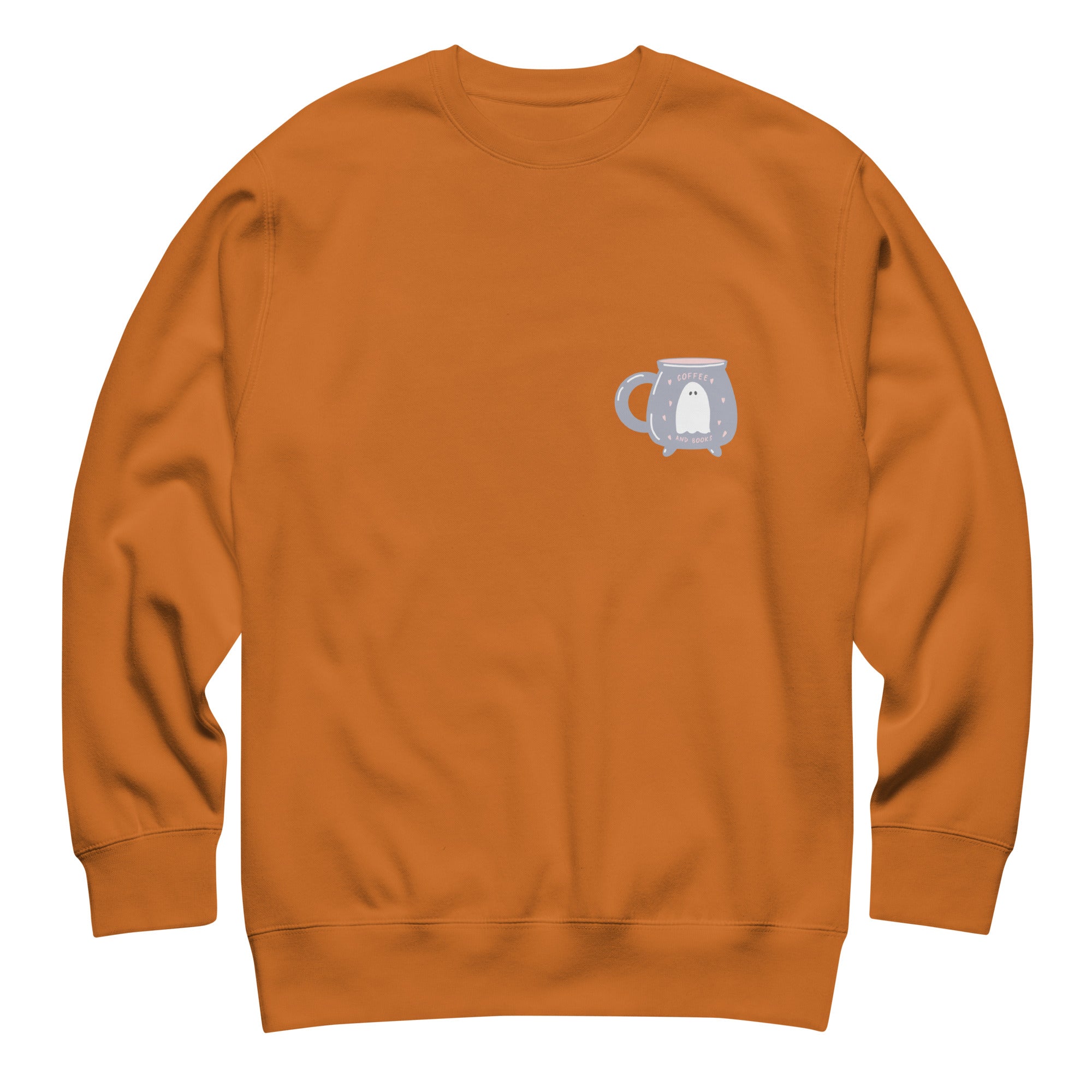Design featuring a ghost inside of a cauldron shaped mug on the right hand side of a burn orange colored sweater. On a white background.