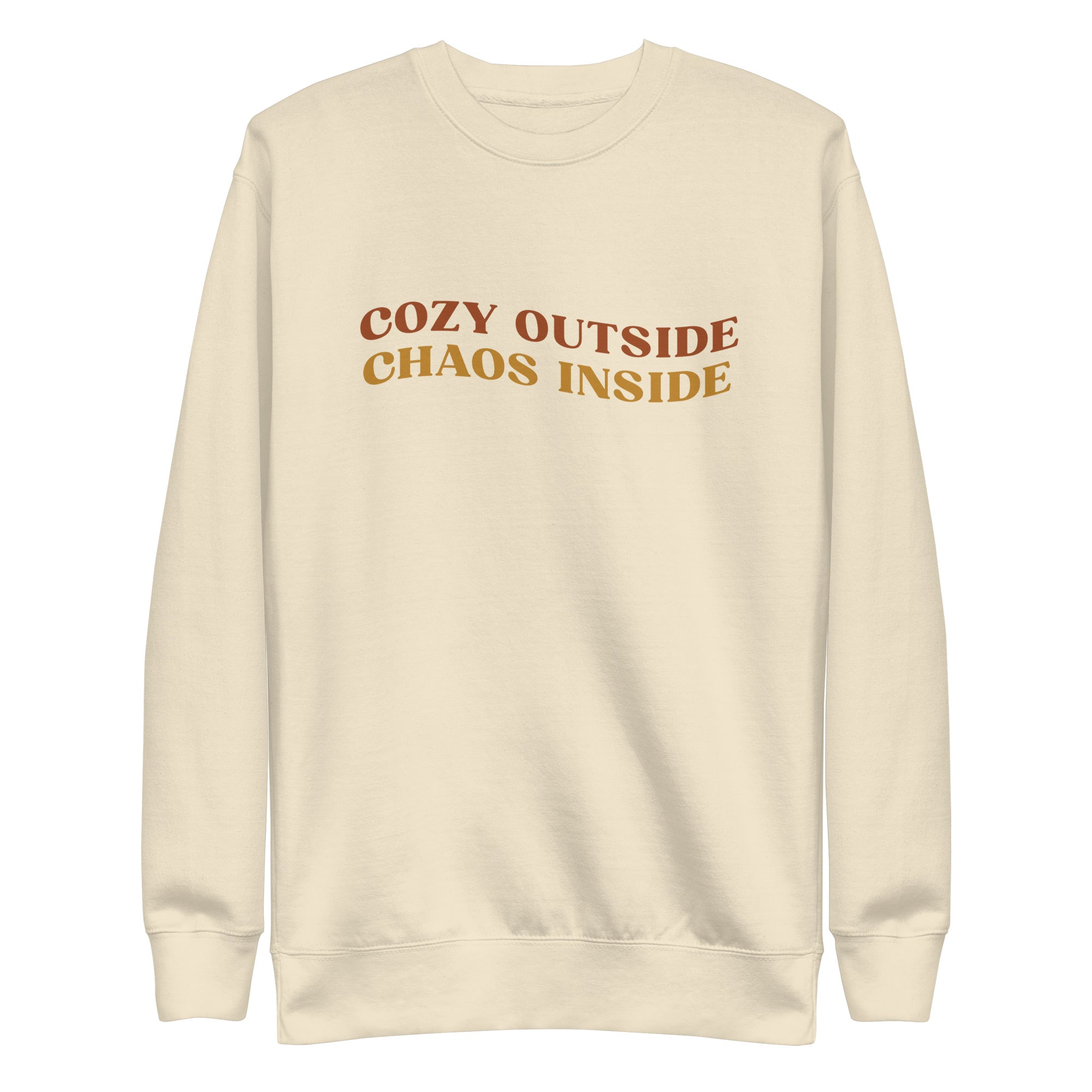 cream sweater with the words "cozy outside chaos inside" written in the center. displayed on white background.