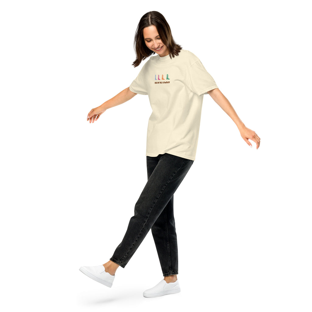 woman wearing beige t-shirt with colorful cowboy boots and text that reads "dibs on the cowboy". Shown on a white background