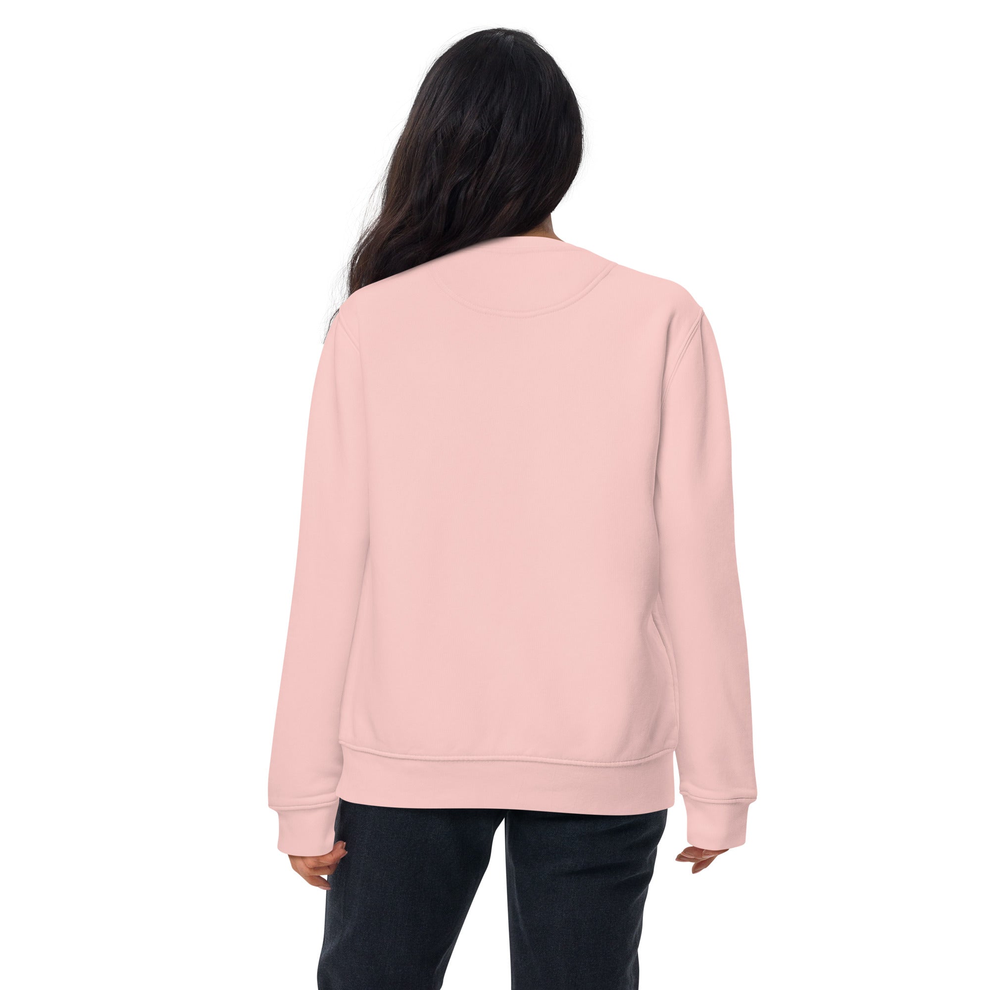 Woman wearing a light pink sweatshirt standing with her back showing on a white background